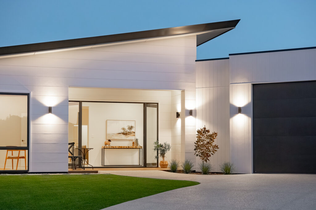 Front of a white home with a skillion roof at dusk
